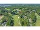 A beautiful aerial view of a home on a golf course featuring a pond, mature trees, and manicured green spaces at 3975 River Hills Dr., Little River, SC 29566