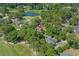 Aerial shot of a brick house nestled in lush greenery with a golf course, pond, and other houses nearby at 3975 River Hills Dr., Little River, SC 29566