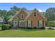 Charming two-story brick home with a well-manicured lawn and a welcoming blue front door and black shutters at 3975 River Hills Dr., Little River, SC 29566