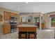 Well-lit kitchen showcasing granite countertops, stainless steel appliances, island with barstools, and tile flooring at 3975 River Hills Dr., Little River, SC 29566