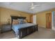 This is a spacious carpeted bedroom featuring a ceiling fan, dark wood furnishings, and ensuite access at 3975 River Hills Dr., Little River, SC 29566