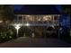 Elevated home with a porch, detailed architecture, and a beautifully lit facade at night at 404 29Th Ave. N, North Myrtle Beach, SC 29582