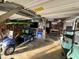Spacious garage equipped with multiple golf carts, tool storage, and decorative wall art creating a functional space at 404 29Th Ave. N, North Myrtle Beach, SC 29582