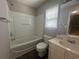 Bathroom showcasing a shower and tub combination, along with a white vanity, toilet, and window at 433 Emerson Dr., Myrtle Beach, SC 29579