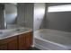 Bathroom showcasing a double sink vanity, bathtub, and a large mirror at 433 Emerson Dr., Myrtle Beach, SC 29579