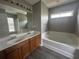 Bathroom showcasing a double sink vanity, bathtub, and a large mirror at 433 Emerson Dr., Myrtle Beach, SC 29579