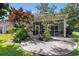 A peaceful backyard setting with a screened porch and circular patio amidst beautiful landscaping and mature trees at 4610 Fringetree Dr., Murrells Inlet, SC 29576