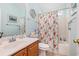 A charming bathroom with wood vanity, white toilet, and shower-tub combo with a whimsical octopus curtain at 4610 Fringetree Dr., Murrells Inlet, SC 29576