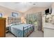 A cozy bedroom featuring a metal frame bed, a window with floral curtains, and vaulted ceiling at 4610 Fringetree Dr., Murrells Inlet, SC 29576