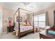 A traditional-style bedroom with a four poster bed, ceiling fan, and neutral decor with pops of color at 4610 Fringetree Dr., Murrells Inlet, SC 29576