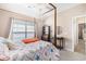A comfy bedroom featuring a four-poster bed with seashell patterned quilt, and neutral decor at 4610 Fringetree Dr., Murrells Inlet, SC 29576