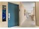 Hallway of condo with a blue door leading to unit 807 and a stained glass window at 4800 Ocean Blvd. S # 1119, North Myrtle Beach, SC 29582