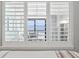 Ocean view from bedroom window with white shutters and sheer curtains visible at 4800 S Ocean Blvd. # 520, North Myrtle Beach, SC 29582