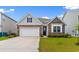 Inviting home exterior featuring stone and siding, a white garage door, and green lawn at 490 Calhoun Falls Dr., Myrtle Beach, SC 29579