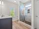 Bright bathroom with stylish vanity, wood-look flooring, and frameless glass shower door at 5004 Shore Breeze Dr., Myrtle Beach, SC 29588