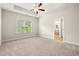 Spacious primary bedroom with a tray ceiling, carpet flooring, and ensuite bathroom at 5004 Shore Breeze Dr., Myrtle Beach, SC 29588