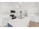 A modern kitchen boasting white cabinets, stainless steel appliances, an island and herringbone tile backsplash at 5009 Shore Breeze Dr., Myrtle Beach, SC 29588
