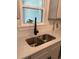 Close up of a stainless kitchen sink with modern faucet and white countertops at 518 Nowell St., Georgetown, SC 29440