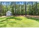 Large backyard with lush green grass and a storage shed perfect for outdoor activities at 589 Boundaryline Dr. Nw, Calabash, NC 28467