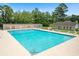 Community pool with clear blue water, surrounding lounge chairs, and nearby clubhouse at 589 Boundaryline Dr. Nw, Calabash, NC 28467