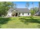 Charming home with a well-manicured lawn and welcoming front porch and outdoor seating area at 589 Boundaryline Dr. Nw, Calabash, NC 28467