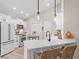 Modern white kitchen featuring stainless appliances, breakfast bar, and stylish pendant lighting at 589 Boundaryline Dr. Nw, Calabash, NC 28467