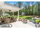 Covered patio area with comfortable seating, a grill, and views of the expansive backyard at 589 Boundaryline Dr. Nw, Calabash, NC 28467