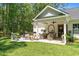 Outdoor patio with a built-in grill, dining area, and views of the lush backyard at 589 Boundaryline Dr. Nw, Calabash, NC 28467