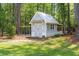 Charming storage shed with white siding, a metal roof, and an attached outdoor enclosure at 589 Boundaryline Dr. Nw, Calabash, NC 28467