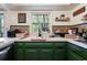 Kitchen with green cabinets, white countertops, tiled backsplash and hardwood floors at 59 Bay Tree Ln., Pawleys Island, SC 29585