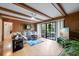 Spacious living room featuring wood paneling, ceiling beams, a cozy sectional and a glass door at 59 Bay Tree Ln., Pawleys Island, SC 29585