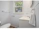White bathroom featuring a bright window and stylish wood look flooring at 602 3Rd Ave. N, Myrtle Beach, SC 29577