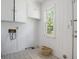 Bright laundry room features tiled floor, a window for natural light, cabinets, and utility connections at 602 3Rd Ave. N, Myrtle Beach, SC 29577