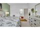 Bright bedroom with floral bedding, pale green accent wall, and ensuite bathroom with a walk-in shower at 6029 Campanella St., Myrtle Beach, SC 29572