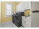 Well-lit laundry room with a side-by-side washer and dryer and white cabinets at 607 Boone Hall Dr., Myrtle Beach, SC 29579