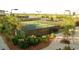 Outdoor tennis court surrounded by green landscaping and a black fence at 607 Boone Hall Dr., Myrtle Beach, SC 29579