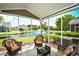 Relaxing screened patio with wicker furniture overlooking a serene pond and fountain at 6172 Catalina Dr. # 113, North Myrtle Beach, SC 29582