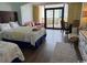 Well-lit bedroom with two beds, dining set, balcony and calming decor at 6900 Ocean Blvd. N # 303, Myrtle Beach, SC 29572