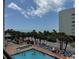 Balcony view of the swimming pool, beach, and lounge chairs at 6900 Ocean Blvd. N # 303, Myrtle Beach, SC 29572