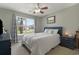 Comfortable bedroom features a large window with neighborhood view, ceiling fan, and attractive decor at 729 Bonita Loop, Myrtle Beach, SC 29588