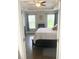 Comfortable bedroom featuring hardwood floors, a tray ceiling, and natural light from the windows at 821 Falkirk St., Myrtle Beach, SC 29579