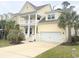 Charming yellow home featuring a double garage, a double porch, and tropical landscaping at 821 Falkirk St., Myrtle Beach, SC 29579