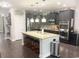 Open kitchen with stainless steel appliances, dark cabinetry, and an island with granite countertops at 821 Falkirk St., Myrtle Beach, SC 29579
