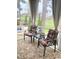 Covered porch area with patterned outdoor rug, comfortable seating and scenic backyard views at 821 Falkirk St., Myrtle Beach, SC 29579