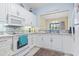 Bright kitchen with white cabinets, tile backsplash, and an open view to the dining area at 824 Castleford Circle # 7C, Myrtle Beach, SC 29572