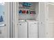 Laundry room featuring a stacked washer and dryer, storage shelves, and white cabinets at 824 Castleford Circle # 7C, Myrtle Beach, SC 29572