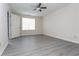 Bright bedroom featuring modern gray flooring, a ceiling fan, and a large window at 890 Holly Sands Blvd., Little River, SC 29566
