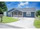 Inviting blue home with a covered porch, bench, and driveway at 890 Holly Sands Blvd., Little River, SC 29566