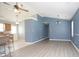 Open-concept living room with wood-look flooring and blue accent wall, leading to kitchen at 890 Holly Sands Blvd., Little River, SC 29566