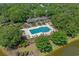 Aerial view of a community pool area with lounge chairs and recreation areas, surrounded by trees and a pond at 907 Tidewater Dr., North Myrtle Beach, SC 29582